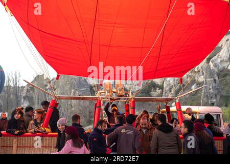 Balloonista che fa fuoco su mongolfiera prima di iniziare i turisti si sono imbarcati nel cestino dell'abitacolo della mongolfiera prima del volo. Cappadocia Foto Stock