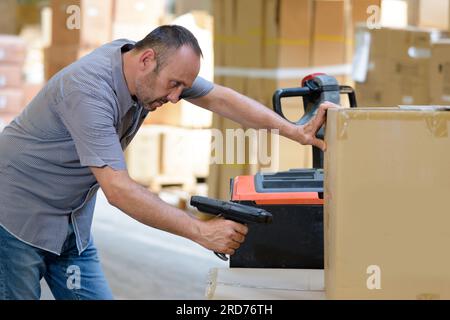 lavoratore che utilizza la casella scansione su palmare Foto Stock