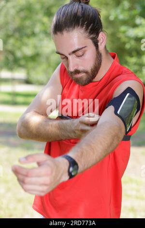 fantastico jogger che regola il suo dispositivo musicale Foto Stock