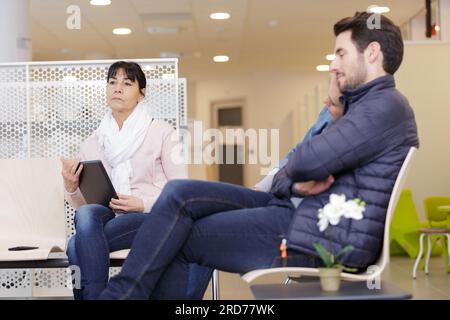 coppia in attesa in sala d'attesa dell'ospedale Foto Stock