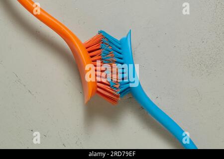 Primo piano delle spazzole arancioni e blu con le setole a contatto Foto Stock