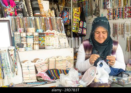 Donna che lavora a maglia la bambola tessitrice al suo stand a Uchisar in Cappadocia Foto Stock