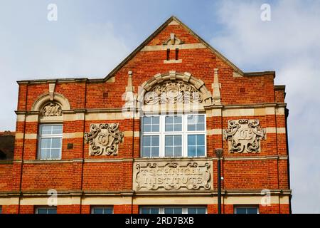 Dettaglio dei piani superiori della facciata in mattoni e pietre dell'edificio della Biblioteca Tonbridge, Tonbridge, Kent, Inghilterra Foto Stock