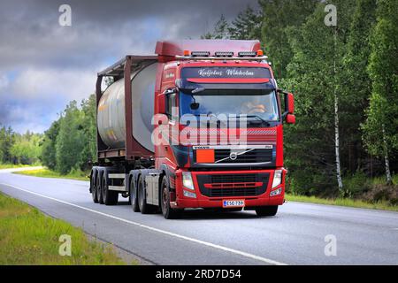 L'autocarro Volvo FH personalizzato di Kuljetus Wikholm Oy trasporta in estate un container cisterna Bertschi sull'autostrada 25. Raasepori, Finlandia. 7 luglio 2023. Foto Stock