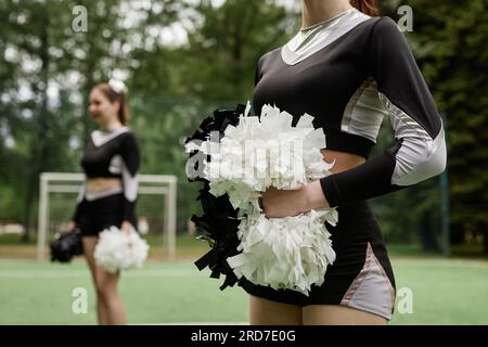 Ragazze con pompon della squadra cheerleader che ballano all'aperto durante la competizione Foto Stock