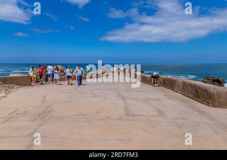 Biarritz, Francia, 03 luglio 2023: Turisti al rocher de la Vierge (roccia vergine di maria) a Biarritz. Aquitania, Paesi Baschi, Francia. Foto Stock