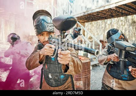 Lavoro di squadra, tiro e paintball con l'uomo in gioco per giochi, guerra e giochi. Sfida, missione e soldato con persone e fumo sul campo di battaglia Foto Stock