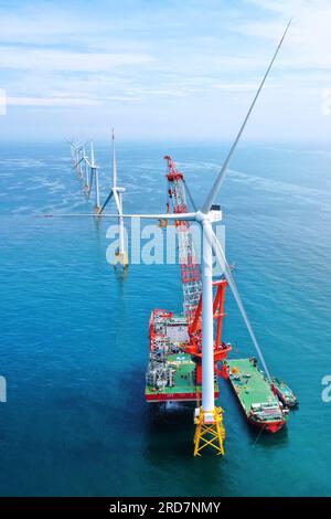 (230719) -- FUZHOU, 19 luglio 2023 (Xinhua) -- questa foto aerea scattata il 28 giugno 2023 mostra una turbina eolica da 16 megawatt installata nel parco eolico offshore del Fujian gestito dalla China Three Gorges Corporation al largo della costa della provincia del Fujian della Cina sudorientale. La prima turbina eolica offshore da 16 megawatt al mondo al largo della costa della provincia di Fujian è stata collegata con successo alla rete e ha iniziato a generare elettricità mercoledì. La turbina eolica ha la più grande capacità di generazione a singola unità tra tutte le turbine in funzione in tutto il mondo, ha affermato la società. Le pale della turbina sono ciascuna di 123 metri Foto Stock