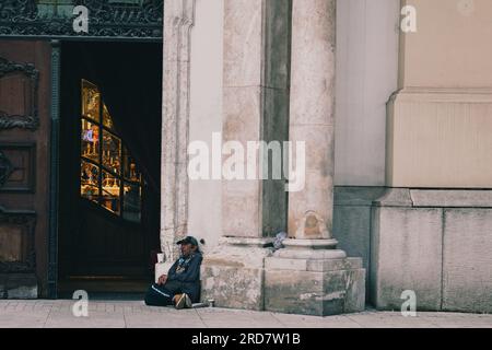 5 maggio 2023, Budapest, Ungheria: Un uomo visto seduto per strada e chiede soldi alla gente. In Ungheria, soprattutto a Budapest, si è diffusa una preoccupazione per i senzatetto. A causa dell'elevata inflazione, la città ha visto un aumento del numero di persone che vivono nelle strade. Fattori come la povertà, la disoccupazione, problemi di salute mentale e la mancanza di alloggi a prezzi accessibili contribuiscono al problema. Il governo ungherese e le autorità locali hanno attuato varie misure per affrontare i senzatetto. Questi includono la fornitura di rifugi di emergenza, servizi sociali e programmi ai Foto Stock