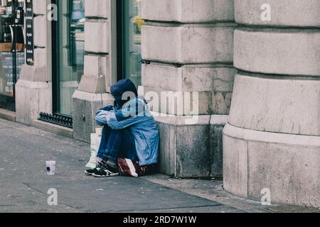 14 maggio 2023, Budapest, Ungheria: Un uomo visto seduto per strada e chiede soldi alla gente. In Ungheria, soprattutto a Budapest, si è diffusa una preoccupazione per i senzatetto. A causa dell'elevata inflazione, la città ha visto un aumento del numero di persone che vivono nelle strade. Fattori come la povertà, la disoccupazione, problemi di salute mentale e la mancanza di alloggi a prezzi accessibili contribuiscono al problema. Il governo ungherese e le autorità locali hanno attuato varie misure per affrontare i senzatetto. Questi includono la fornitura di rifugi di emergenza, servizi sociali e programmi A. Foto Stock