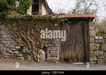 Un'antica porta in legno in un edificio residenziale storico nel villaggio di Trava nel distretto di Lauco, provincia di Udine, Friuli-Venezia Giulia, ne Italia Foto Stock