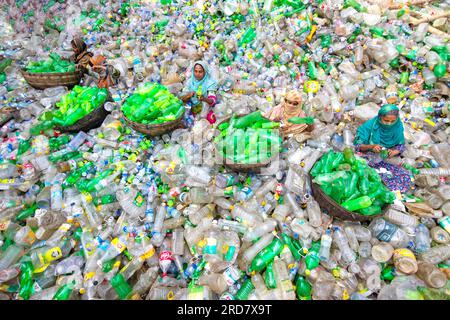 19 luglio 2023, Dacca, Bangladesh: I lavoratori selezionano bottiglie di plastica in una fabbrica di riciclaggio a Dacca, Bangladesh. I dipendenti aiutano a evitare che le bottiglie vengano smaltite, inviate in discarica, dove possono impiegare 1.000 anni per biodegradarsi, o incenerite, che produce fumi tossici. Il consumo annuo pro capite di plastica di Dacca è più di tre volte la media nazionale per le aree urbane e si attesta a 22,25 kg. Circa 646 tonnellate di rifiuti di plastica vengono raccolte ogni giorno a Dacca, che rappresenta il 10% di tutti i rifiuti generati in Bangladesh. Solo il 37,2% dei rifiuti di plastica a Dacca viene riciclato. (Credi Foto Stock