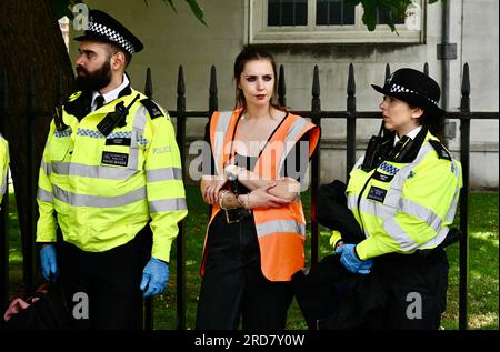 Londra, Regno Unito. Un attivista della JSO ammanettato è detenuto e attende il trasporto dalla piazza. Just Stop Oil ha marciato oggi per chiedere che il governo fermi tutti i nuovi progetti nel settore del petrolio e del gas. Crediti: michael melia/Alamy Live News Foto Stock