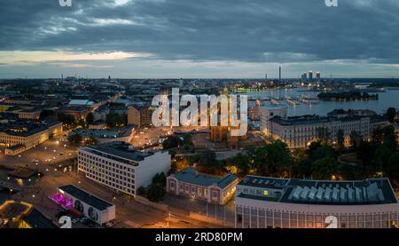 Luci dagli edifici e dalla chiesa storica nel porto di Helsinki all'alba Foto Stock