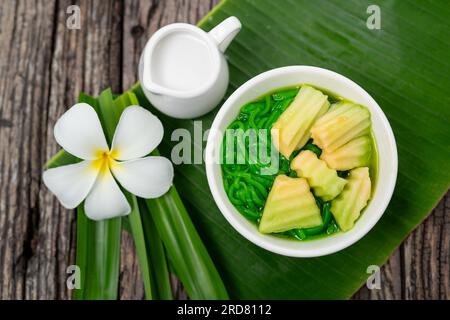 Vista dall'alto del dessert tailandese Lod Chong con foglie di pandan su fondo di legno. Foto Stock