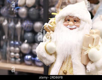 Babbo Natale giocattolo per l'arredamento natalizio, sullo sfondo delle palle di Natale in pacchetti Foto Stock