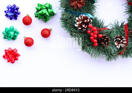 Sfondo per il nuovo anno, decorazioni natalizie su sfondo bianco, banner. Corona di Natale con nastri e coni, palline di Natale e fiocchi Foto Stock