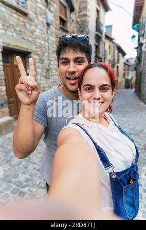 Selfie di una giovane coppia che fa turismo rurale in un villaggio di montagna. Vacanze e vacanze estive all'aperto a Huesca, Spagna Foto Stock