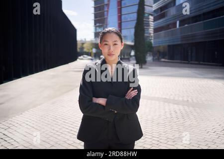 Ritratto giovane donna d'affari asiatica seria che guarda le braccia della fotocamera incrociate. Donna cinese sicura di sé Foto Stock