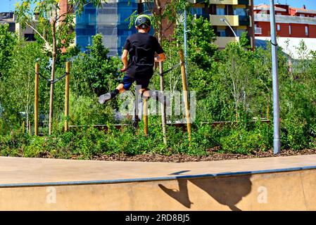 Giovane che pratica lo Scootering (Freestyle Scootering) nel nuovo Skatepark del parco centrale di Igualada, Barcellona, Spagna Foto Stock