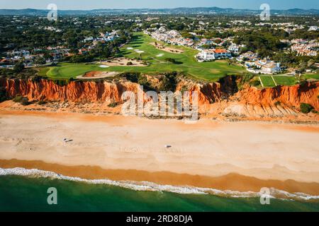 Vista aerea con droni della Praia de vale do Lobo con magnifici campi da golf affacciati sull'oceano in Algarve, Portogallo, Europa Foto Stock