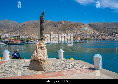 Vista della statua nella città portuale di Kalimnos con colline sullo sfondo, Kalimnos, isole del Dodecaneso, isole greche, Grecia, Europa Foto Stock