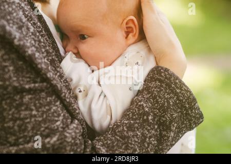 Mamma culla un neonato in piedi per strada. Foto Stock