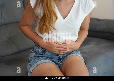 Giovane donna con dolore addominale da coliche del periodo durante il ciclo mestruale Foto Stock
