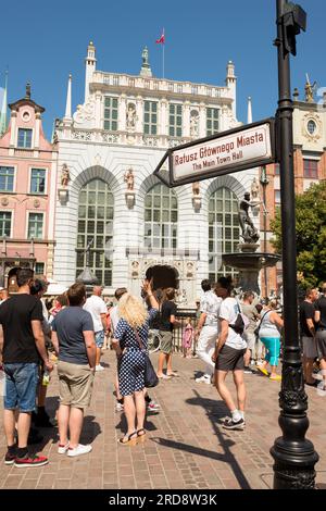 Turisti fuori dall'edificio storico di Artus Court a Dlugi Targ, nella città vecchia di Danzica, Polonia, Europa, UE Foto Stock