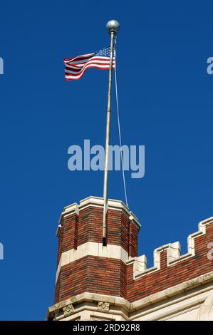 Vivid blue skies frame American flag flying over the old Hot Springs High School building in Hot Springs, Arkansas.  This building is the alma mater o Stock Photo