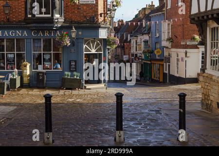 Il pub Magna carta sulla Exchequer Gate nel centro di Lincoln, Lincolnshire, Regno Unito, con vista sulla ripida strada. Foto Stock