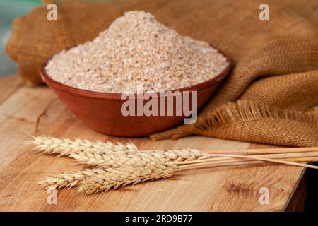 Crusca di grano in una ciotola di argilla e spighe di grano su fondo di  legno. Sfondo alimentare sano. Cibo e ingredienti da forno. con copyspace  Foto stock - Alamy