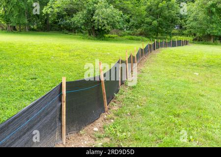 Tessuto Silt Fence con pali in legno installati prima dell'inizio della costruzione. Foto Stock