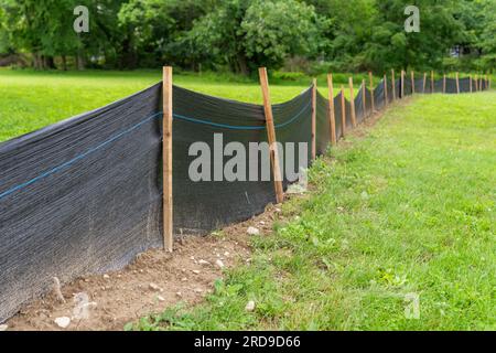 Tessuto Silt Fence con pali in legno installati prima dell'inizio della costruzione. Foto Stock