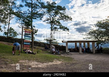 Tegucigalpa, Francisco Morazan, Honduras - 11 dicembre 2022: La gente si trova nell'erba e sulle panchine in un punto panoramico nel Parco "El Picacho" Foto Stock