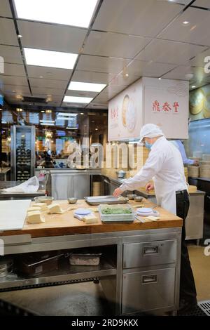 Cuochi e personale di cucina preparano gnocchi, bao e altri dim sum cinesi al ristorante DIN Tai Fung al centro commerciale Taipei 101 a Taipei, Taiwan. Foto Stock