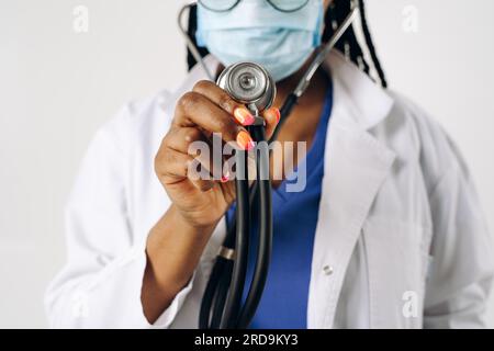 bella medico afro-americana che indossa maschera con stetoscopio Foto Stock