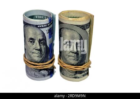 Rotoli di 100 banconote da cento dollari denaro contante vecchia e nuova serie arrotolata con bande di gomma con il ritratto del presidente Benjamin p. Foto Stock