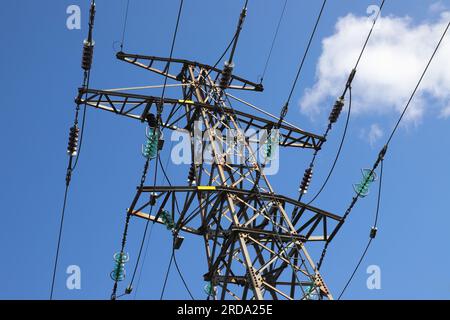 Vista angolare bassa di un pilone elettrico ad alta tensione. Foto Stock