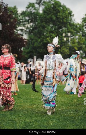 Donna nativa americana vestita con tradizionale abito da jingle all'evento pow wow per celebrare la cultura indigena Foto Stock