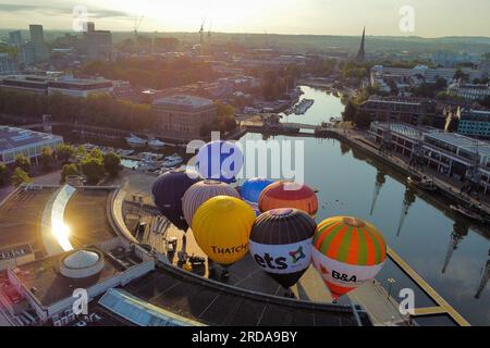 Le mongolfiere si gonfiano e si allacciano da Bristol Harbourside la mattina presto, quando inizia il conto alla rovescia per la Bristol International Balloon Fiesta del 2023 ad Ashton Court Estate in agosto. Data foto: Giovedì 20 luglio 2023. Foto Stock