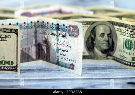 Banconote americane ed egiziane , mucchio di vecchie banconote retrò 100 dollari americani con pila piegata EGP libbre egiziane LE, mone Foto Stock