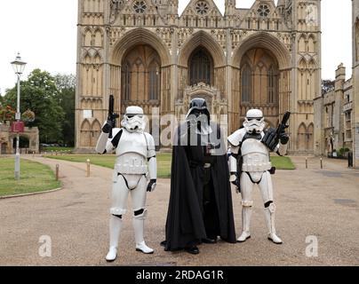 Peterborough, Regno Unito. 18 luglio 2023. Darth Vadar e Stormtroopers si posano fuori dalla Cattedrale di Peterborough prima che una delle più grandi collezioni private di fan di Star Wars al mondo possa essere vista nella magnifica Cattedrale di Peterborough dal 19 luglio. La mostra, galassie non ufficiali, presso la Cattedrale di Peterborough, comprende oltre 120 mostre, con un Land Speeder a grandezza naturale in mostra insieme a giocattoli e oggetti rari di Star Wars. Peterborough, Cambridgeshire, Regno Unito. Credito: Paul Marriott/Alamy Live News Foto Stock