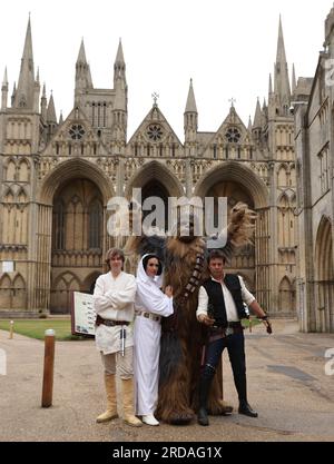 Peterborough, Regno Unito. 18 luglio 2023. Luke Skywalker, Princess Leia, Chewbacca e Han solo posano fuori dalla Cattedrale di Peterborough prima che una delle più grandi collezioni private di fan di Star Wars al mondo possa essere vista nella magnifica Cattedrale di Peterborough dal 19 luglio. La mostra, galassie non ufficiali, presso la Cattedrale di Peterborough, comprende oltre 120 mostre, con un Land Speeder a grandezza naturale in mostra insieme a giocattoli e oggetti rari di Star Wars. Peterborough, Cambridgeshire, Regno Unito. Credito: Paul Marriott/Alamy Live News Foto Stock