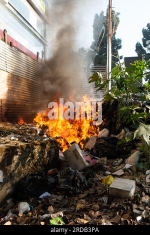 18 novembre 2022. Combustione di rifiuti inorganici che producono grandi fiamme e fumi neri. Uttarakhand India. Foto Stock