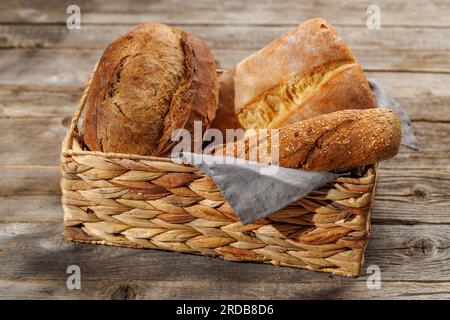 Varietà di pane assortite in un incantevole cestino, pronto per essere gustato Foto Stock