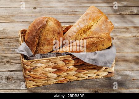 Varietà di pane assortite in un incantevole cestino, pronto per essere gustato Foto Stock