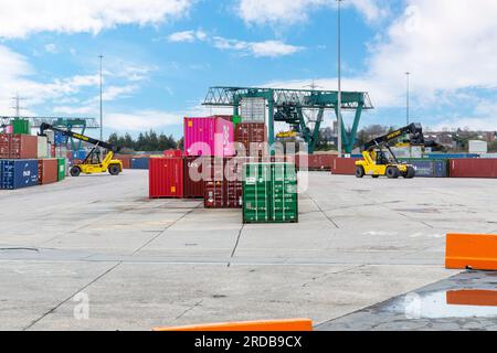 Un veicolo con caricatore dall'alto si sposta e accumula container per spedizioni intermodali presso un ICD (Inland Container Depot) in Inghilterra. Foto Stock