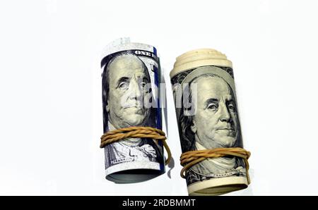 Rotoli di 100 banconote da cento dollari denaro contante vecchia e nuova serie arrotolata con bande di gomma con il ritratto del presidente Benjamin p. Foto Stock