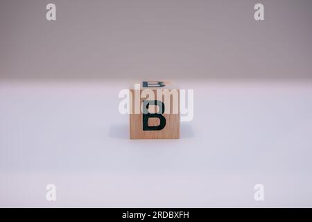 Blocco di legno scritto "B" con sfondo bianco. Foto Stock